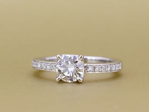 センターストーンの左右にダイヤモンドをあしらい、ハーフエタニティに