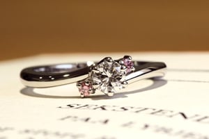 両サイドのピンクダイヤモンドが可憐な印象