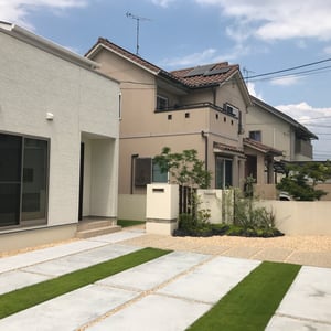 ご来客用の駐車スペースとして普段は解放されている玄関周りの空間に、無機質なコンクリートだけでなく芝生で緑のラインを追加することで柔らかい印象にしました。