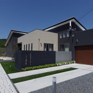 ガレージへの舗装はタイヤ跡の目立たないコンクリートのハケ引き仕上げです。玄関へのアプローチと舗装の仕上げを変えることにより、来訪者が視覚的に進路方向を理解できるようにしています。　　岡山市北区Y様邸　エクステリア　フラワーチルドレン