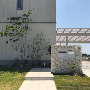 アプローチには既設のタイルと同じものを貼り合わせ、門壁には天然石灰岩を使用し、植栽と共に風合いが楽しめる素材をチョイス。