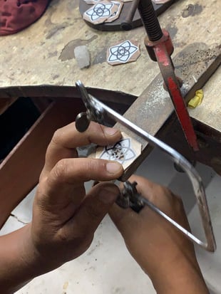 Goldschmied beim Sägen des Venusblume Anhängers