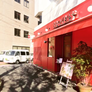 セブンイレブンを過ぎるとすぐ赤い外壁のハンバーガー屋さんが見えますので、お店を過ぎたら右折をお願い致します。