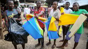 Ein Strassenhändler in Daressalam (l.) verkauft herkömmliche Plastiktüten, während die Händler rechts von ihm Alternativen präsentieren.