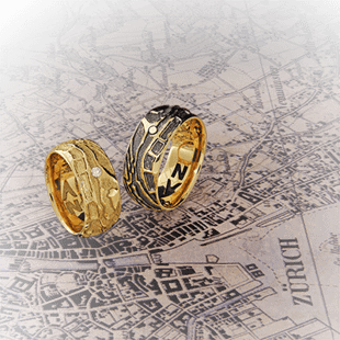 Partnerringe im Landkarten-Relief in Gelbgold mit den persönlichen Koordinaten vom Kunde von der Goldschmiede OBSESSION