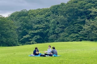 屋外で仲間と輪になり、思いを共有するグループ対話の場面