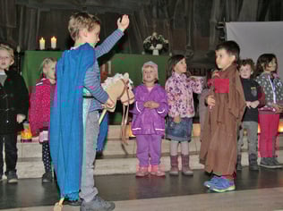 Die Kindergarten Kinder spielen die Geschichte vom heiligen Martin, der seinen warmen Mantel mit einem frierenden Bettler teilt.