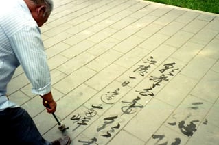 ein Kaligraphie-Künstler schreibt seine Verse auf das Pflaster 