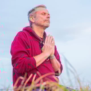 Eine Person meditiert ruhig in einer weiten Berglandschaft