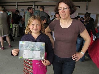 En présence de la directrice, Monique Birchall, Léa, élève de CM2, montre son diplôme d'écocitoyen.