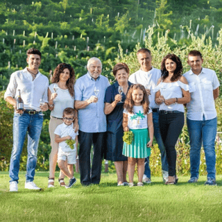 Menschen mit Sektgläsern vor Weinbergen