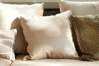 Beige bank? Met deze kleur kussens creëer je veel sfeer