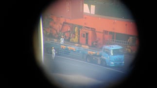 望遠鏡からの画像。ちょうどトレーラーに40フィートコンテナを積むところ。作業員の様子が丸見え。