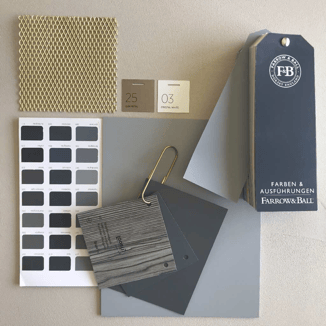 Die Materialauswahl und Kombinationen sind Basis deines Mythos. Bild mit Oberflächenmuster in Grautönen  und Holzmaserung. Linoleum Muster in Grau- und gold streckgitter Metall und Farbmusterfächer von Farrow & Ball.