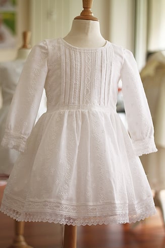 Robe baptême fille en broderies anglaises et dentelle de Calais manches longues. Modèle robe de baptême Héloise, création Fil de Légende. Magasin vêtements baptême Paris, Neuilly-sur-Seine. Expédition en France et à l'international.