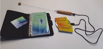 Frequenzkarten liegend auf der Transmitterscheibe mit Energierute und Anleitungsringbuch aufgeschlagen