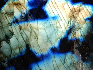 Labradorit - Aus bestimmten Winkeln betrachtet, zeigt dieses Feldspat-Mineral einen irisierenden Glanz, der allgemein als Schillereffekt bezeichnet wird.