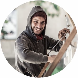 Marcus Scheffczyk blickt von seiner Arbeit am Punktiergerät lächelnd in die Kamera