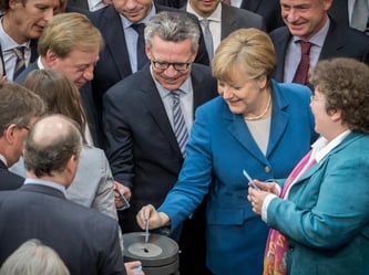 Kanzlerin Merkel und Innenminister de Maiziere während der namentlichen Abstimmung im Bundestag. Foto: Michael Kappeler