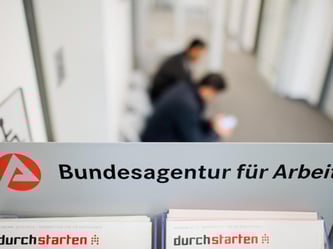 Zwei Männer warten in der Bundesagentur für Arbeit. Foto: Julian Stratenschulte /Illustration