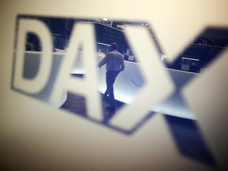 Ein Börsenhändler spiegelt sich im Logo des Deutschen Aktienindexes (DAX). Foto: Fredrik von Erichsen