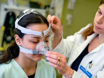 Die Leiterin des Schlaflabors im Klinikum Nürnberg, Dora Triche (r), betreut eine Patientin mit Schlaf-Apnoe. Schlafprobleme werden immer häufiger untersucht. Foto: Daniel Karmann