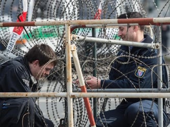 Bei der Arbeit: Polizisten verstärken die Absperrungen vor dem EZB-Neubau. Zur Eröffnung wird mit heftigen Protesten gerechnet. Foto: Boris Roessler