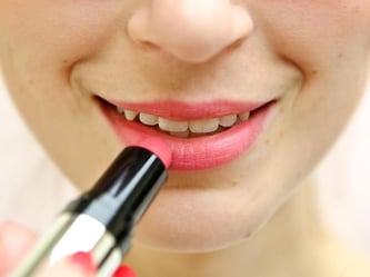 Junge Frau mit Lippenstift. Bereits vor dem zwölften Geburtstag kauft mehr als die Hälfte der Mädchen das erste Schminkprodukt. Foto: Jan Woitas