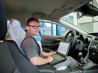 Der Auszubildende Alexander Mathes arbeitet in einer Werkstatt an einem Auto. Foto: D.Karmann/Archiv