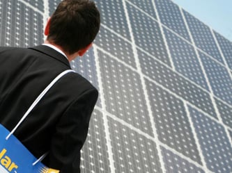 Ein Besucher betrachtet auf der Messe Intersolar ausgestellte Solarmodule. Foto: Tobias Hase/Archiv