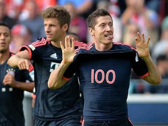 Robert Lewandowski (r) freut sich im Spiel gegen Mainz über sein 100. Bundesligator. Foto: Torsten Silz