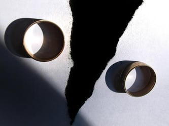 Zwei getragene Eheringe liegen auf einem zerrissenen Papier. Foto Karl-Josef Hildenbrand/Illustration Foto: Karl-Josef Hildenbrand