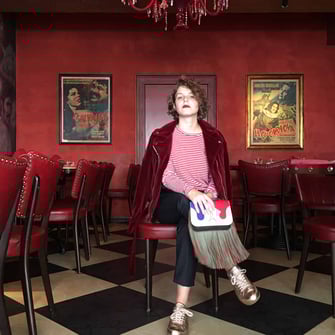 Streetstyle Fotoshoot in einer Bar mit Roten Lederstühlen , roten Wänden und SW kariertem Boden 