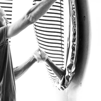 Philipp hängt einen chromstahl Spiegel von Zieta auf.