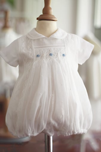 Barboteuse baptême bébé garçon en mousseline et coton blanc avec dentelle et smocks. Barboteuse été Louis. Magasin vêtements cérémonie bébé Fil de Légende Paris, Neuilly-sur-Seine.