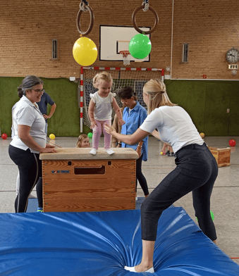 Foto: Kind springt vom Kasten auf die Matte