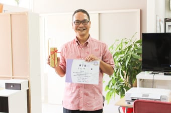 記念品と修了書を持っている卒業生の画像