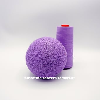 Die Wollkugel wird mit Seide oder Garn umwickelt.