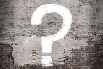 Un gros point d’interrogation est peint sur un mur.