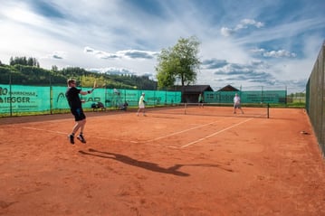 Drei Tennisspieler beim Spiel auf dem Tennisplatz