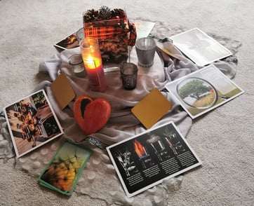 Kerzen, Karten, ein Herz am Boden im Kreis liegend