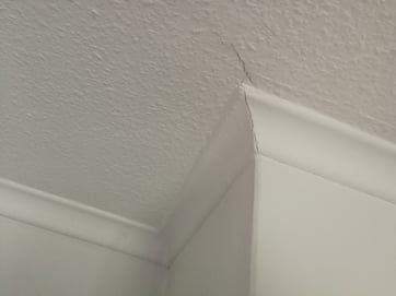 Photograph of minor cracks found in polystyrene coving and ceiling paper