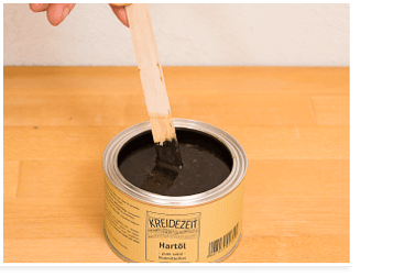 Öle und Wachse pigmentieren: mit dem Rührholz rühren