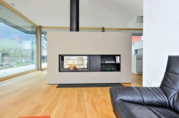 Monoblocco per camino STAFFIERI: Il caminetto a tunnel bifacciale permette di vedere e godere del fuoco a legna da due lati, rendendolo un vero e proprio richiamo visivo come divisorio della stanza.