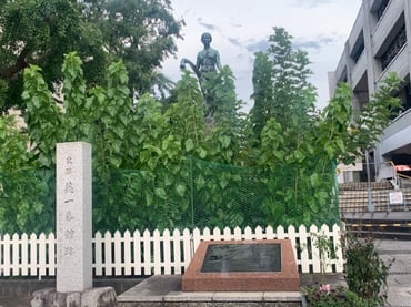 桑の木と『絹と女』像〈手前:英一番館跡碑、右:シルクセンター〉