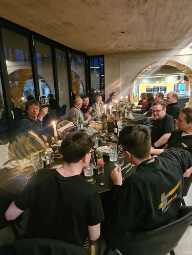 Foto des Teams während des Essens an einer langen Tafel.