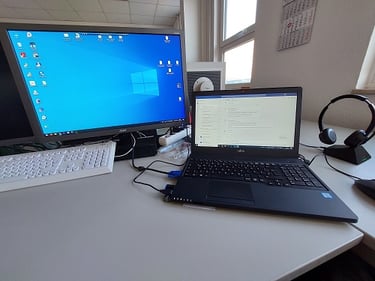 Foto vom Schreibtisch mit Bildschirm und Notebook