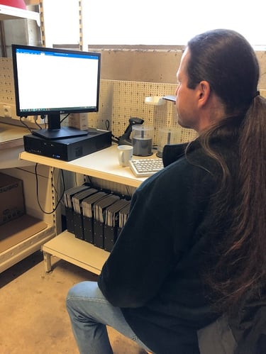 Ein Foto eines Technikers am Schreibtisch während er Mails checkt.