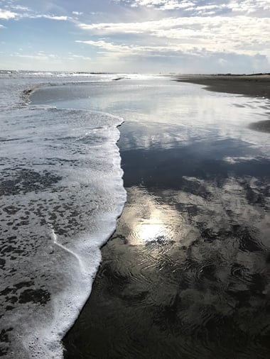 波と海岸にうつる太陽