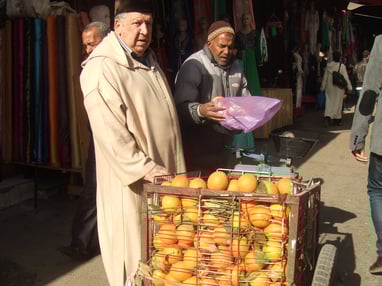 オレンジを売るおじいさん。モロッコは日本と違って野菜や果物は「計り売り」です。
